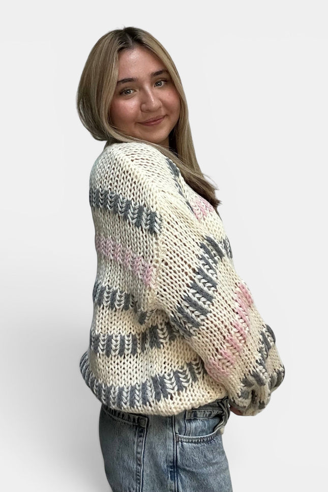 Cozy ivory striped sweater with a chunky knit texture and drop shoulders.