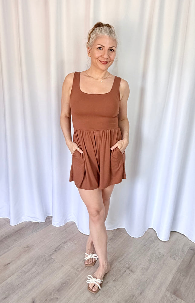Woman wearing a soft hazelnut romper with a flattering square neckline.