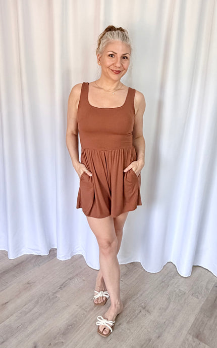 Woman wearing a soft hazelnut romper with a flattering square neckline.