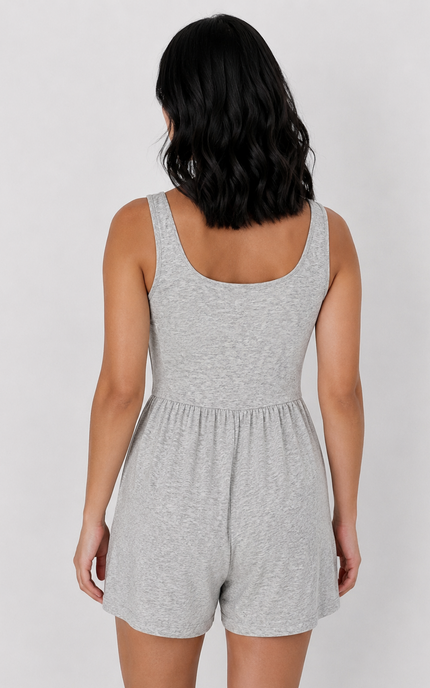 A woman shown from the back wearing a light heather gray sleeveless romper against a plain light gray studio background.