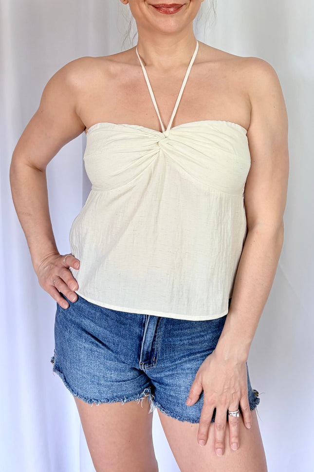 Ivory sleeveless halter top with subtle bead accents and lightweight comfort.