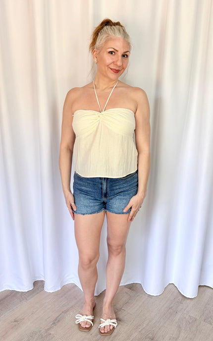 Women's ivory halter top with a flowy silhouette and elevated twist-front detail.