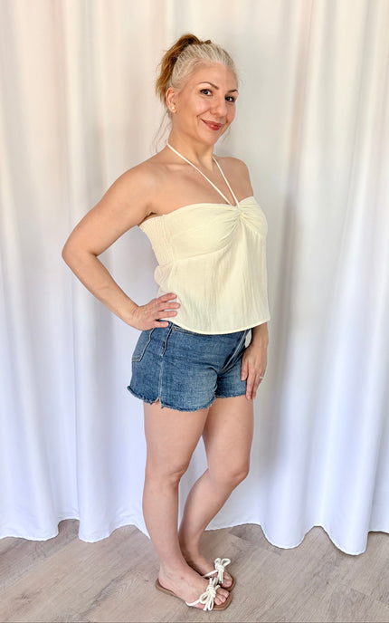 Relaxed-fit ivory halter top made from breathable Tencel blend fabric.