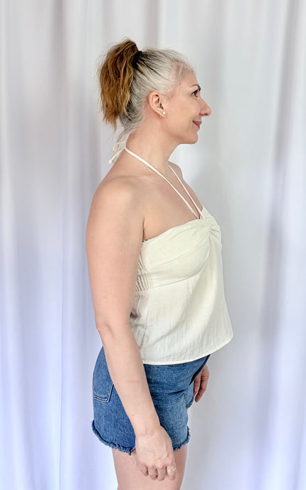 Right side view of an ivory halter top showcasing its relaxed fit and graceful drape.