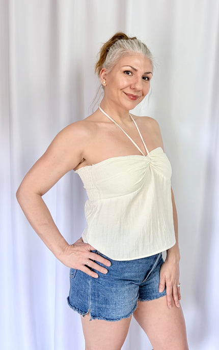 Side view of an ivory halter top showcasing its relaxed fit and graceful drape.