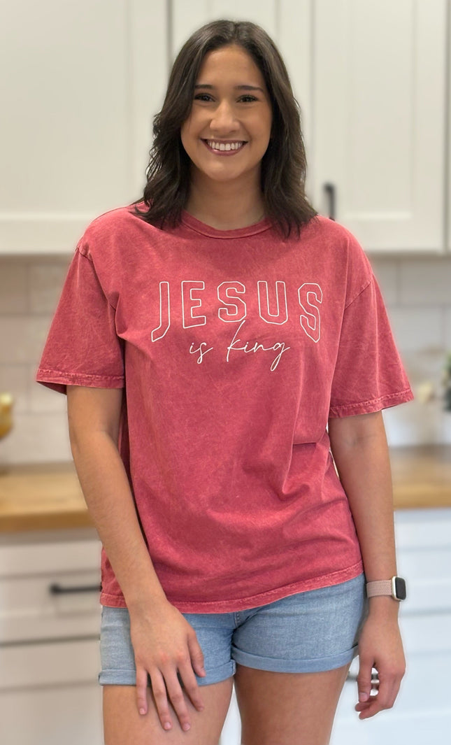 Red mineral-wash “Jesus Is King” graphic tee with relaxed unisex fit and vintage garment-dyed finish.