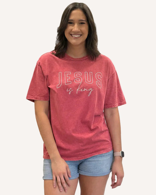 Red mineral-wash “Jesus Is King” graphic tee with relaxed unisex fit and vintage garment-dyed finish.