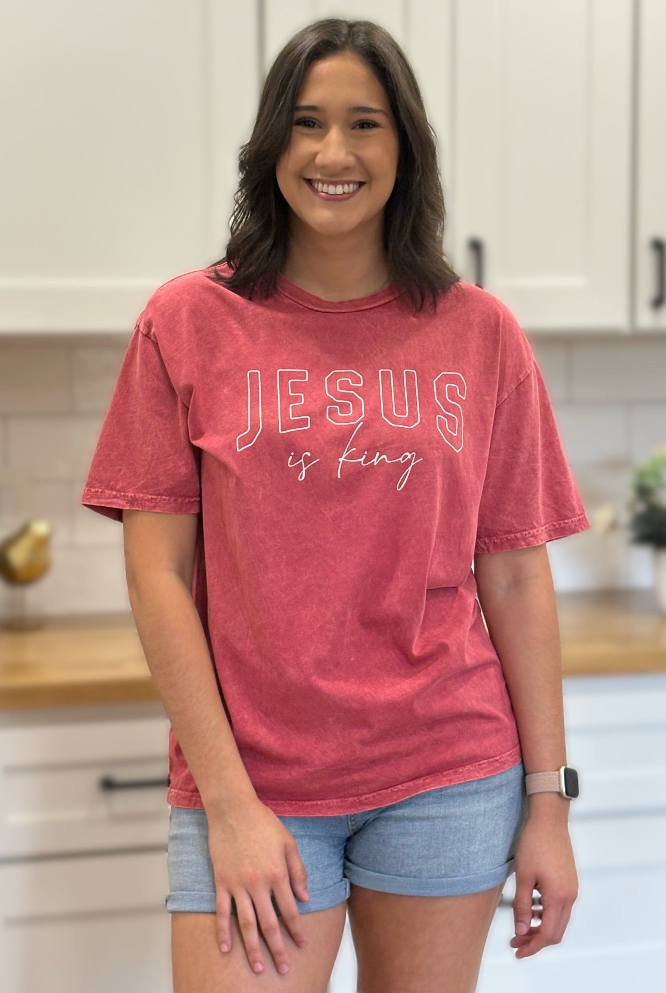 Red mineral-wash “Jesus Is King” graphic tee with relaxed unisex fit and vintage garment-dyed finish.