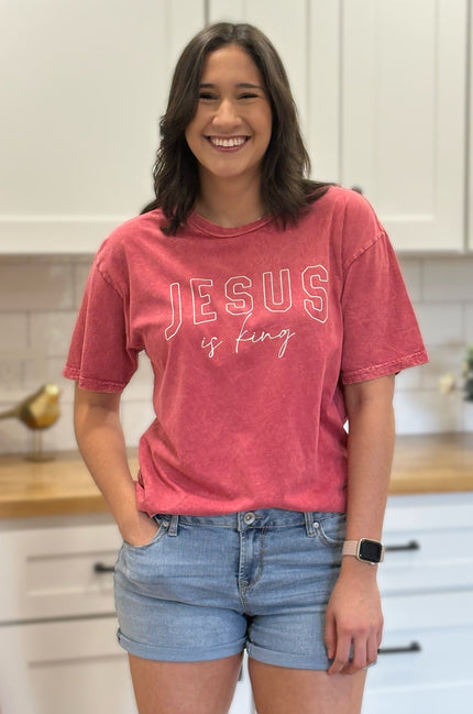 Red mineral-wash “Jesus Is King” graphic tee with relaxed unisex fit and vintage garment-dyed finish.