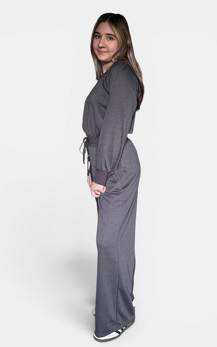 Women's dark gray knit jumpsuit with a wide neckline and relaxed fit.