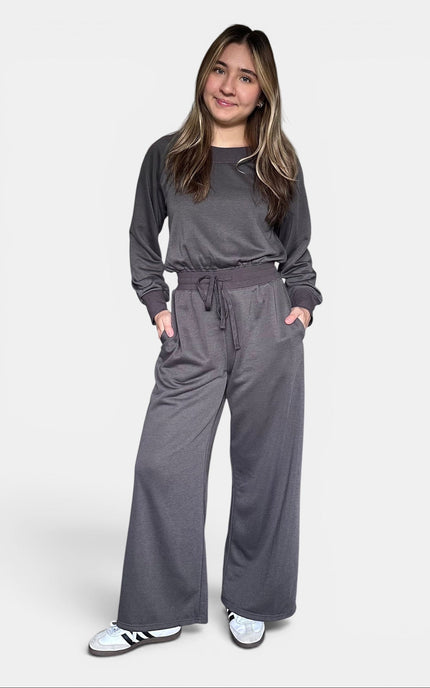 Relaxed dark gray knit jumpsuit with a convertible off-the-shoulder neckline.