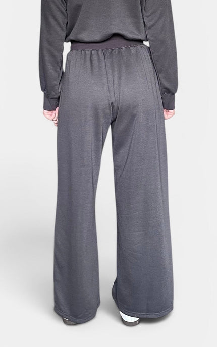 Back view of a dark gray knit jumpsuit with an off-the-shoulder neckline.