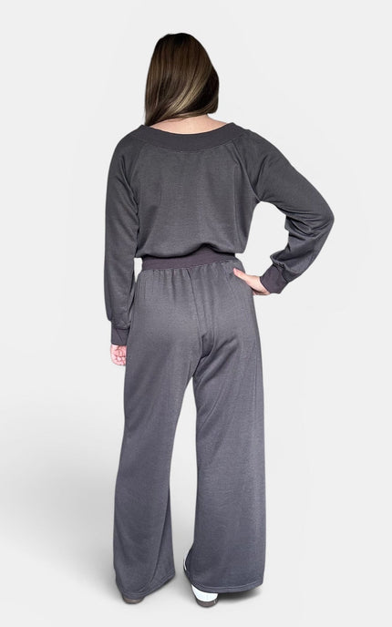 Back view of a dark gray knit jumpsuit with an off-the-shoulder neckline.