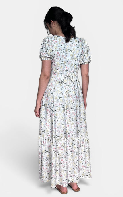 Back view of floral maxi dress with partially smocked waist and puff sleeves