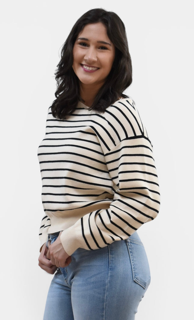Side view of women's asymmetric boat neck long sleeve knit top.