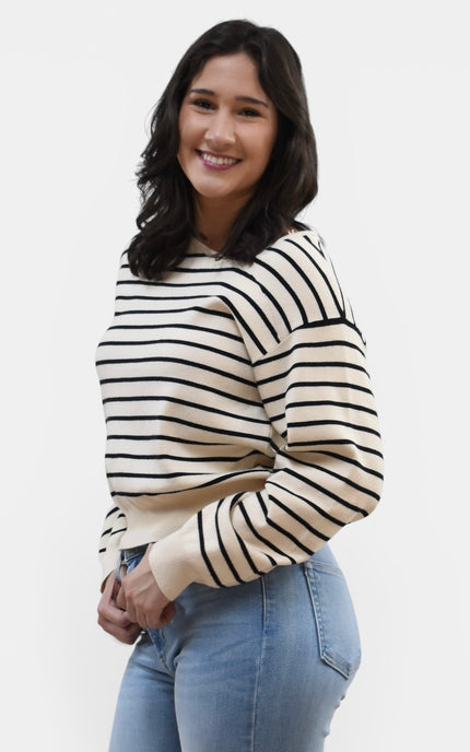 Side view of women's asymmetric boat neck long sleeve knit top.