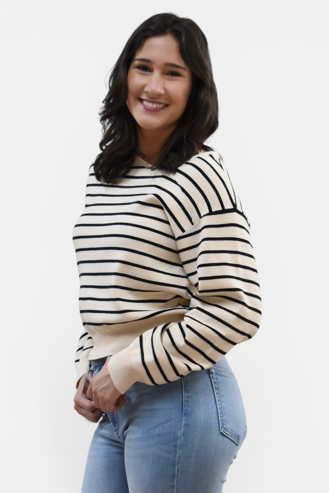 Side view of women's asymmetric boat neck long sleeve knit top.