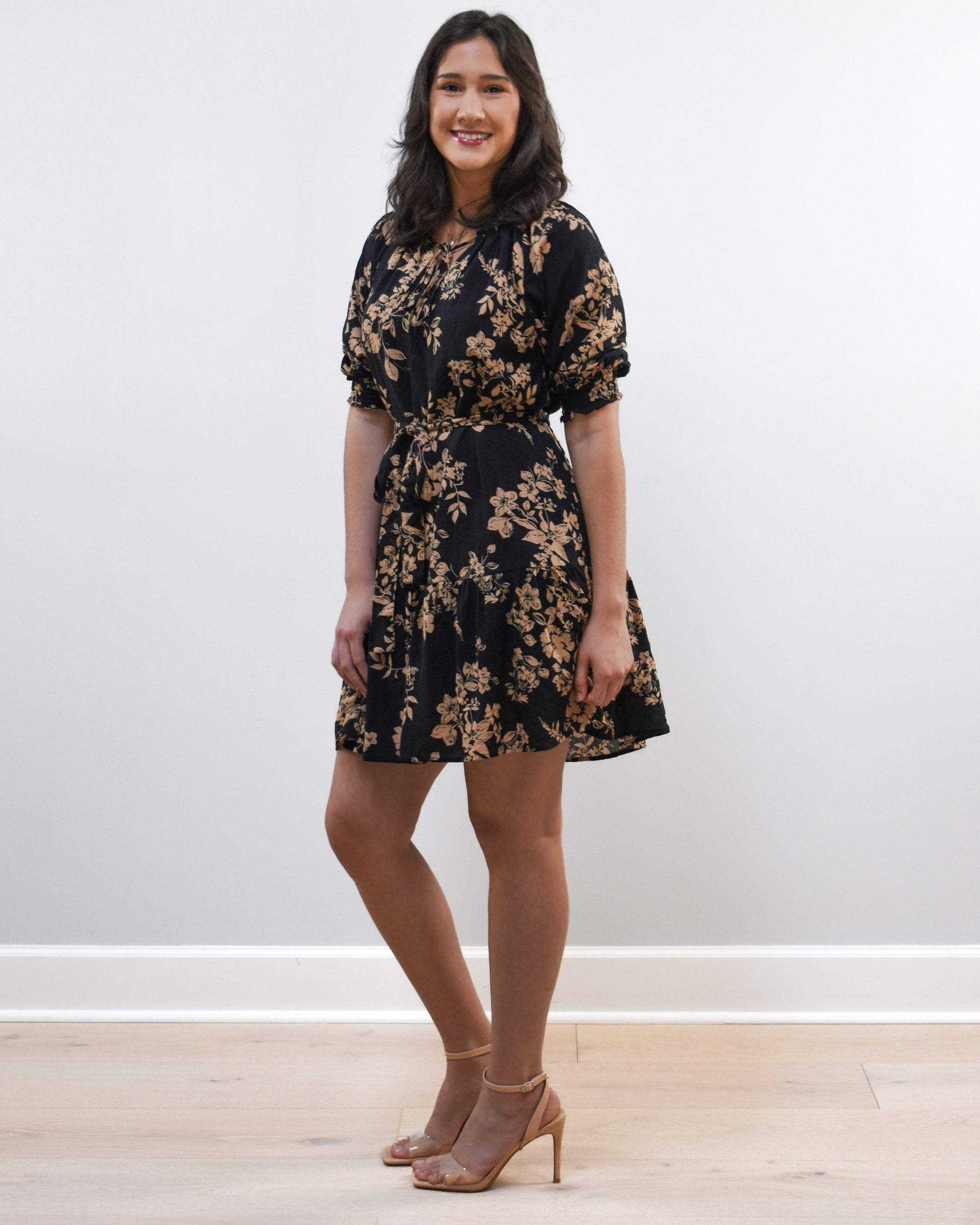 Kelly Mini Dress on soft linen background, featuring a ruffle neckline with tie and lightweight cotton–rayon fabric.