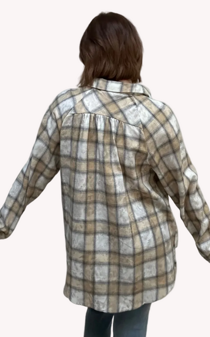 Person wearing a plaid shirt on a plain background