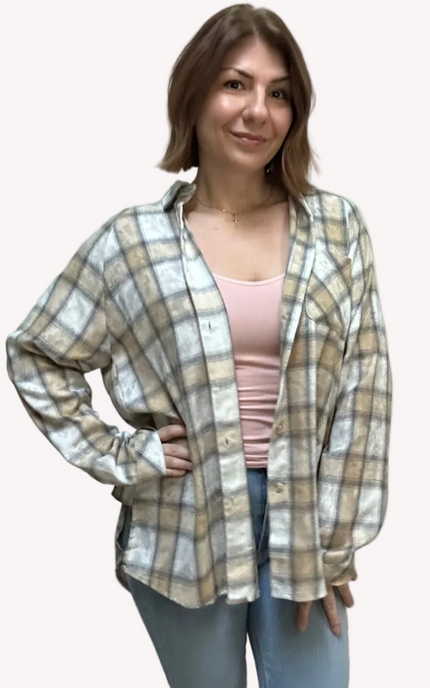 Woman wearing a plaid shirt over a pink top on a plain background