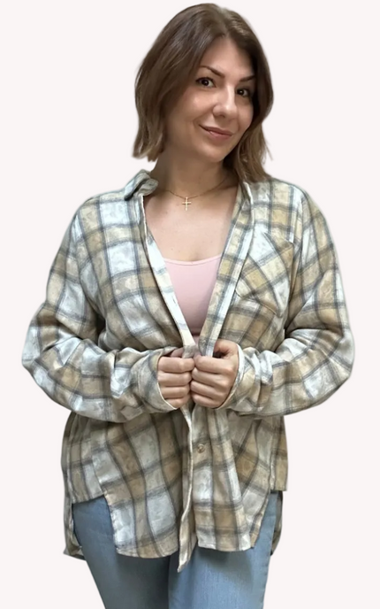 Woman wearing a plaid shirt over a pink top on a light pink background