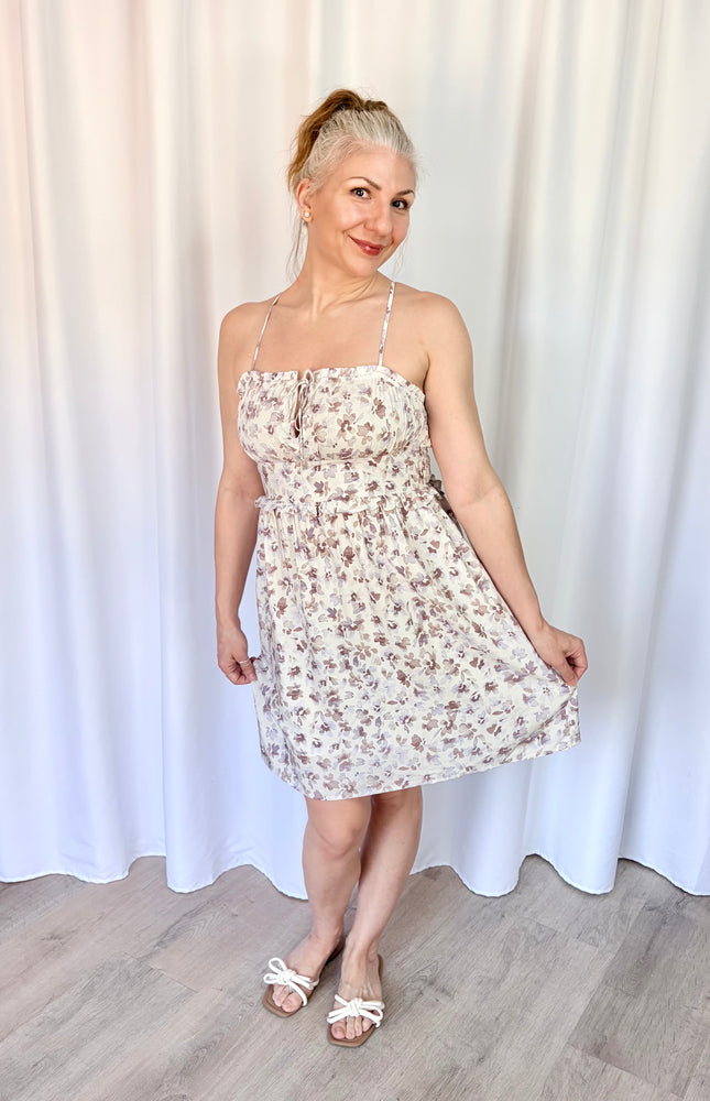 Feminine lavender floral mini dress with pockets, flutter sleeves, and a romantic floral print.