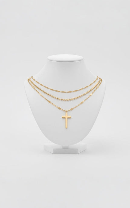 Triple‑chain gold necklace with cross pendant displayed on neutral background, waterproof stainless steel.