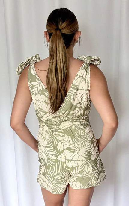 Back view of romper showing smocked waist and adjustable tie shoulder straps.