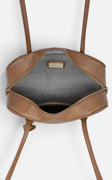 A top-down view of a brown faux-croc leather handbag with its zipper open, showing a gray interior lining and a small gold-tone brand plaque.