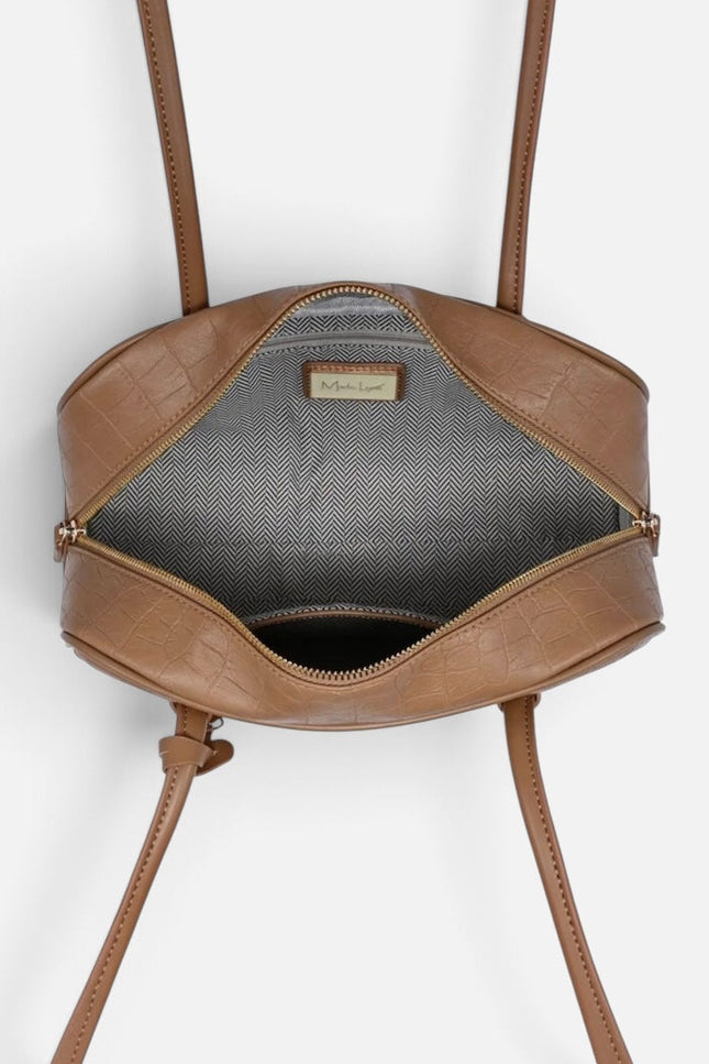 A top-down view of a brown faux-croc leather handbag with its zipper open, showing a gray interior lining and a small gold-tone brand plaque.