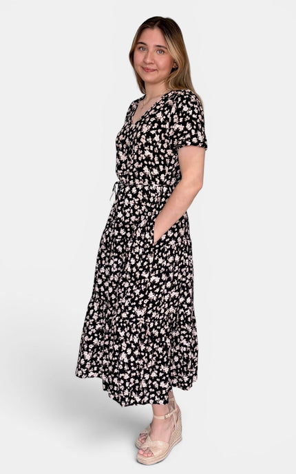 Short-sleeve midi dress with a black and white floral pattern, standing against a light gray studio background.