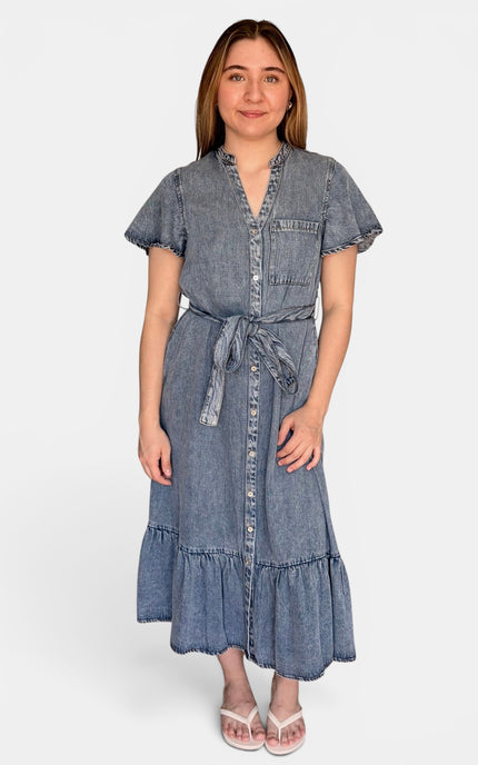 A short-sleeve tencel denim midi dress with a tie waist, button front, and ruffled hem, photographed against a plain light gray studio background.