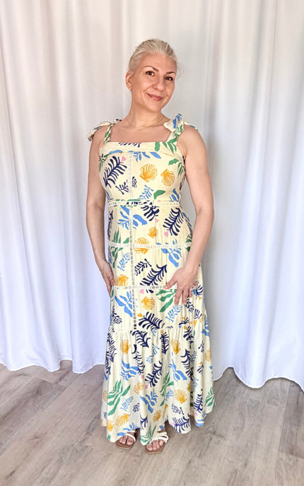 A full-length front view of the Marina Maxi Dress, capturing the model standing in a relaxed, natural pose that emphasizes the effortless coastal charm and long, flowing silhouette of the 100% cotton dress.