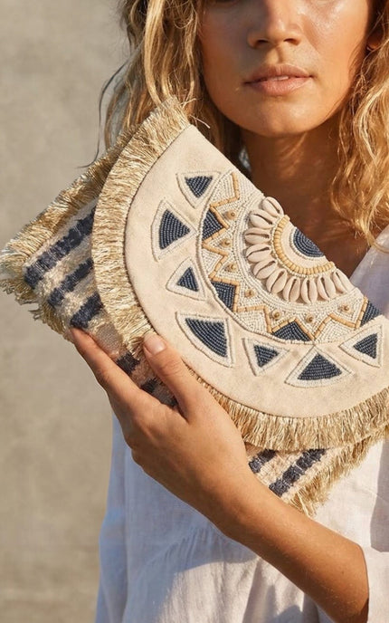 Hand‑beaded navy and cream mandala clutch with soft fringe trim and oversized envelope silhouette.