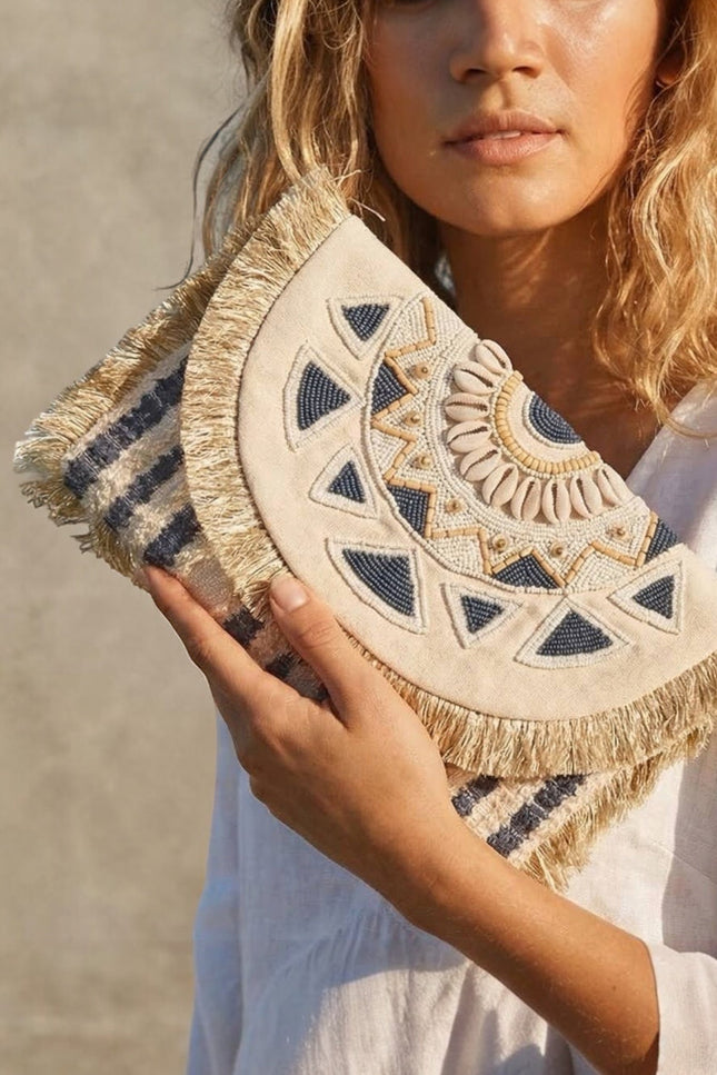 Hand‑beaded navy and cream mandala clutch with soft fringe trim and oversized envelope silhouette.