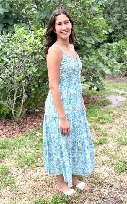 Side view of the model wearing the maxi dress, showing the flattering silhouette and how the border print wraps around the skirt.