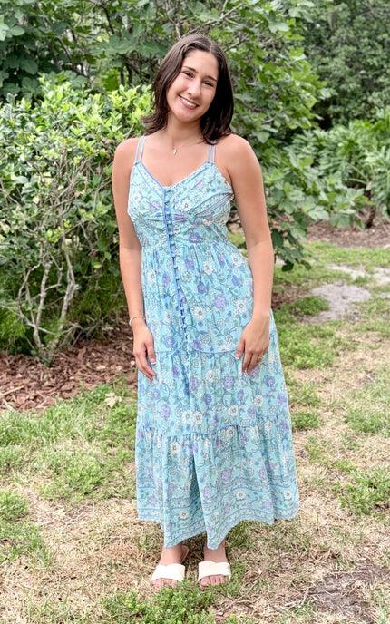 Full-length view of the vibrant border-print maxi dress, showing its lightweight flow and elegant V-neckline against a natural backdrop.