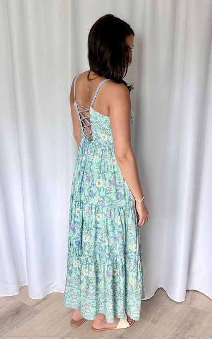 Full-length back view of the maxi dress, highlighting the striking corset tie-up back and the comfortable elastic waistband.