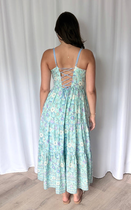 Full-length back view of the maxi dress, highlighting the striking corset tie-up back and the comfortable elastic waistband.