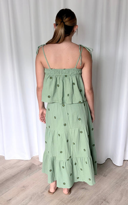 Back view of floral embroidered double gauze matching set showing tiered midi skirt silhouette and tie-shoulder tank with adjustable strap detail
