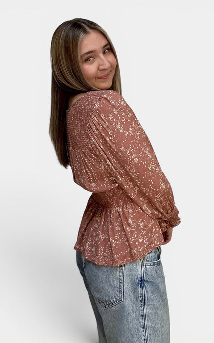Side view of women's flowy floral peasant blouse.