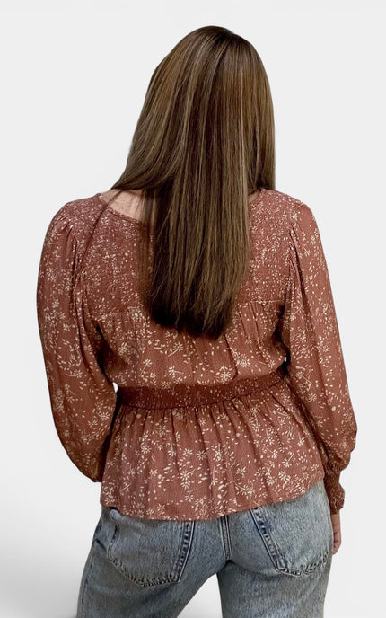 Back view of women's floral peasant top with smocked shoulders.