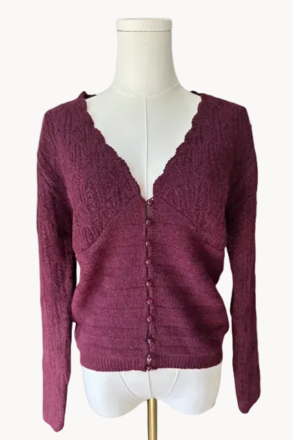Maroon cardigan on a mannequin against a light pink background