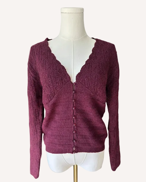 Maroon cardigan on a mannequin against a light pink background