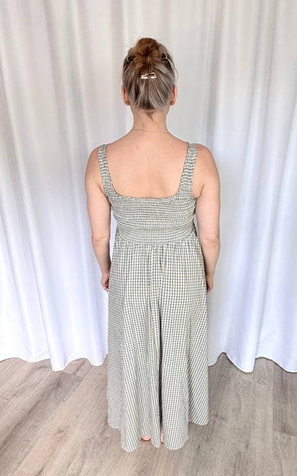 Full-length back view of the gingham Nora Maxi Dress, highlighting the tailored, fitted back silhouette, wide shoulder straps for balanced coverage, and a smooth, elegant drape to the floor.
