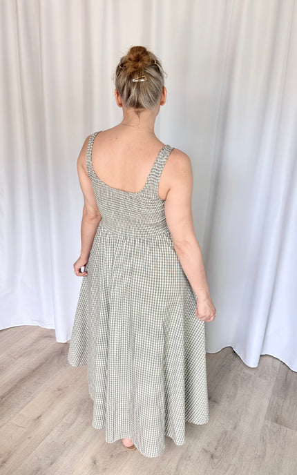 Full-length back view of the gingham Nora Maxi Dress, highlighting the tailored, fitted back silhouette, wide shoulder straps for balanced coverage, and a smooth, elegant hang to the floor.