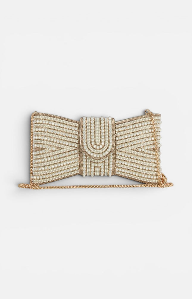 Front view of a cream rectangular clutch featuring a large, ornate bow made of white pearls set in a polished gold-tone frame.