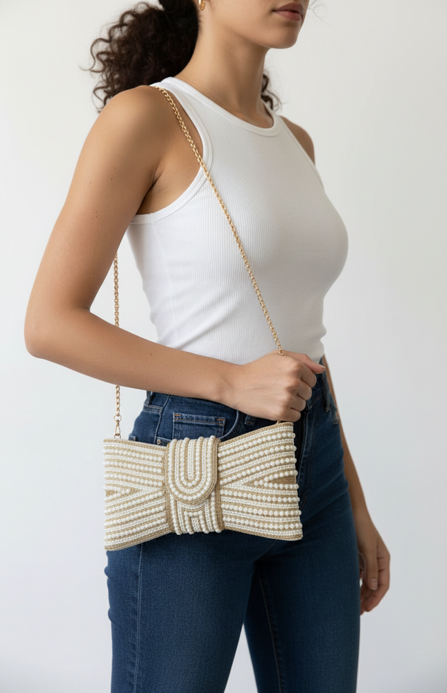 Clutch worn with the detachable shoulder strap for hands‑free styling.