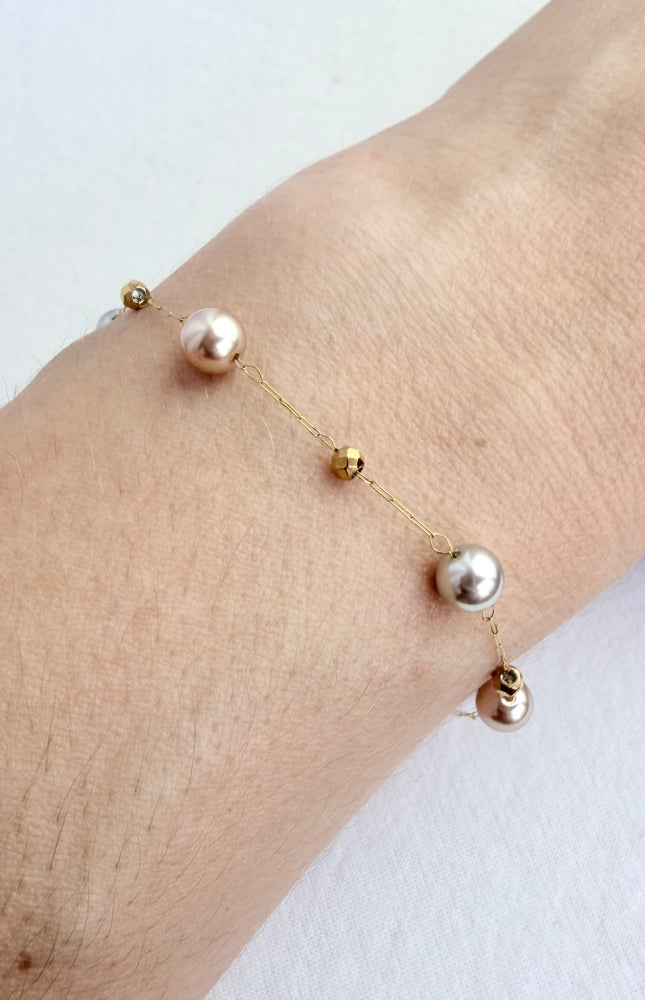 Hypoallergenic gold bracelet featuring imitation pearl accents and a secure clasp.