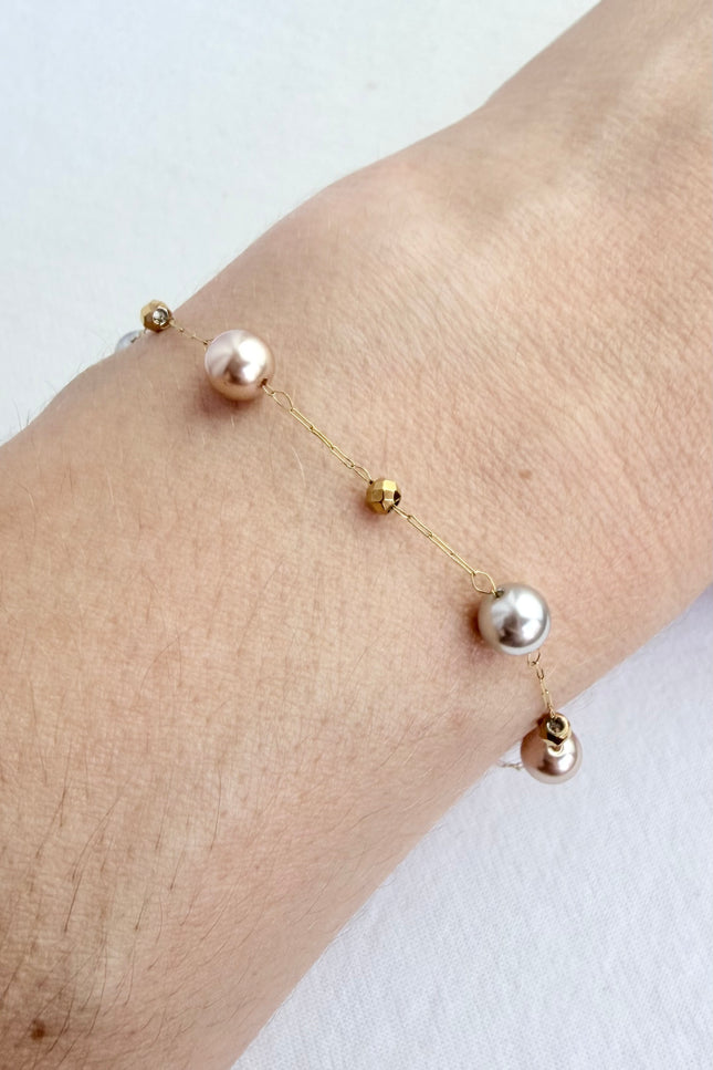 Hypoallergenic gold bracelet featuring imitation pearl accents and a secure clasp.